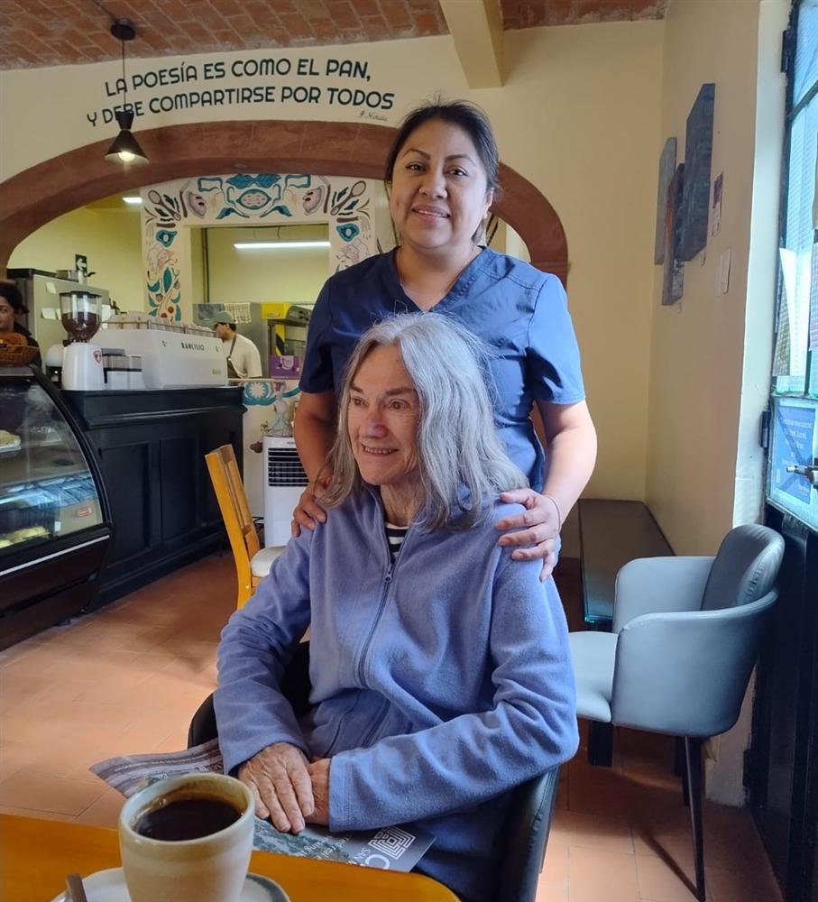 Cuidadora acompañando a una paciente en una cafetería