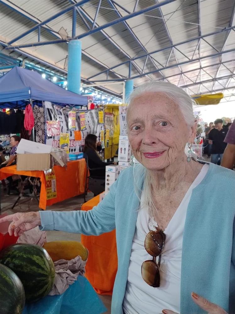 Paciente paseando por un mercado lleno de flores y frutas