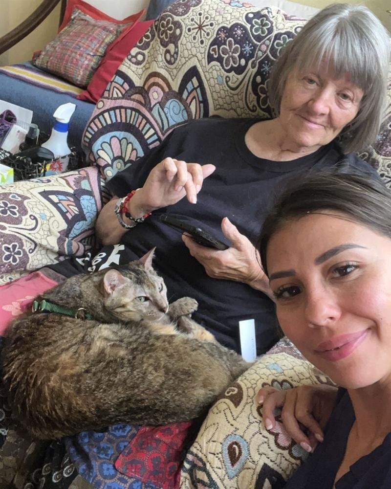 Paciente descansando en el sillón con su gato, junto a su cuidadora